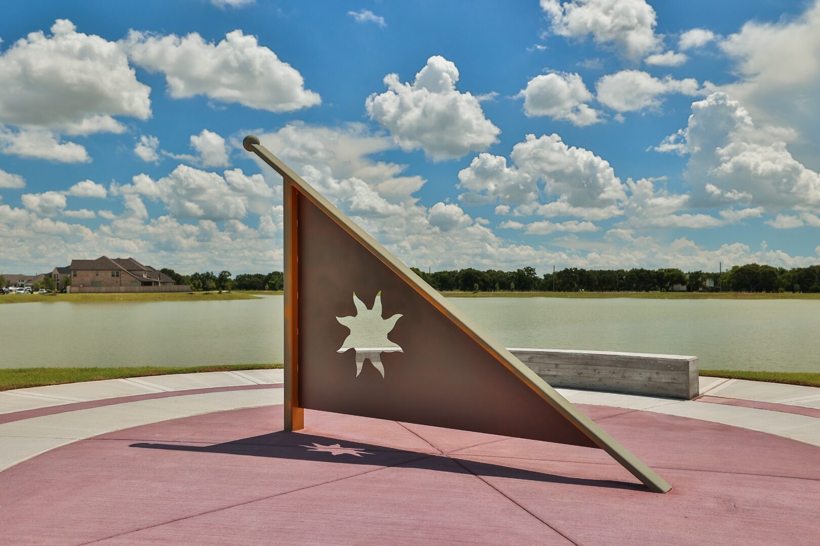 Detail of triangular Corten sundial with cut-metal sun emblem